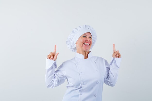 woman chef pointing up in white uniform and looking optimistic