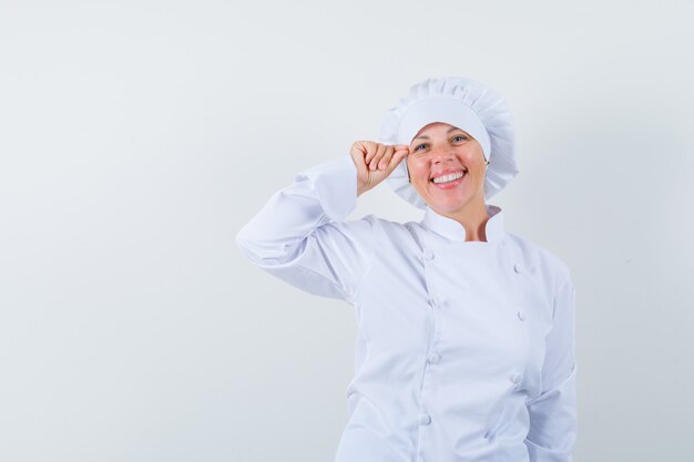 woman chef pretending to do makeup in white uniform and looking pretty