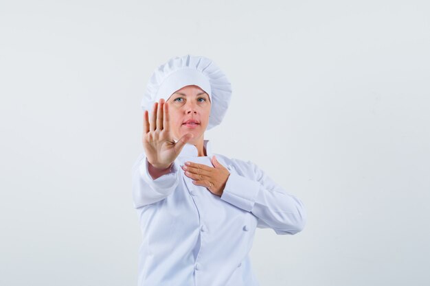 woman chef rejecting something in white uniform and looking reluctant
