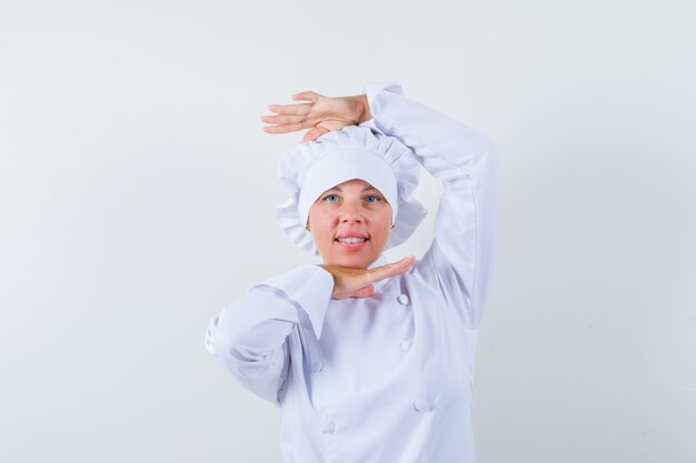 woman chef showing dance gesture in white uniform and looking charming.