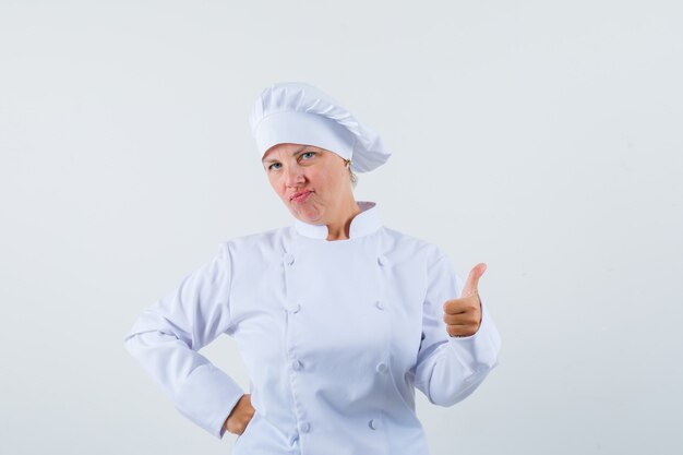 woman chef showing thumb up in white uniform and looking pleased