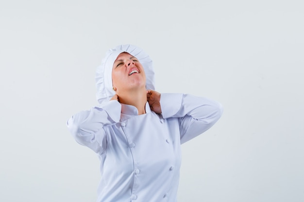 Foto gratuita chef donna soffre di dolore al collo in uniforme bianca e sembra a disagio