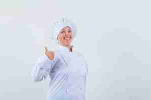 Free photo woman chef in white uniform showing thumb up and looking glad