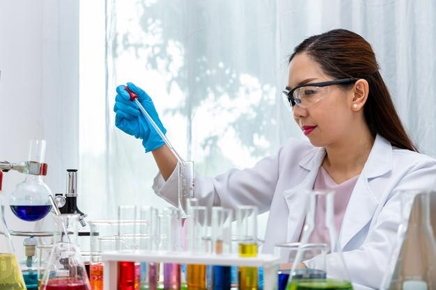 Woman chemist scientist conducting experiment in laboratory with equipment science concept