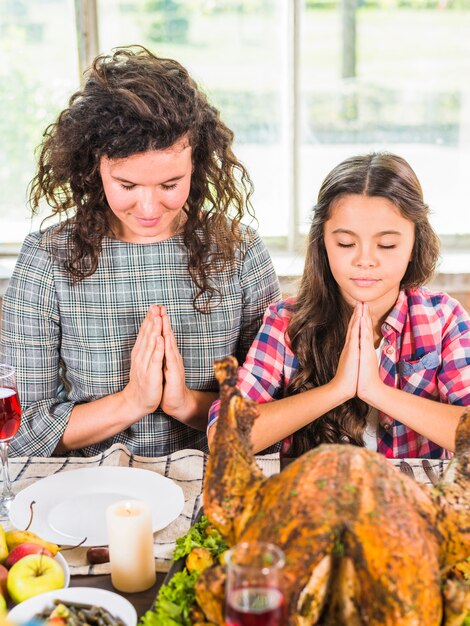 Woman and child praying at table