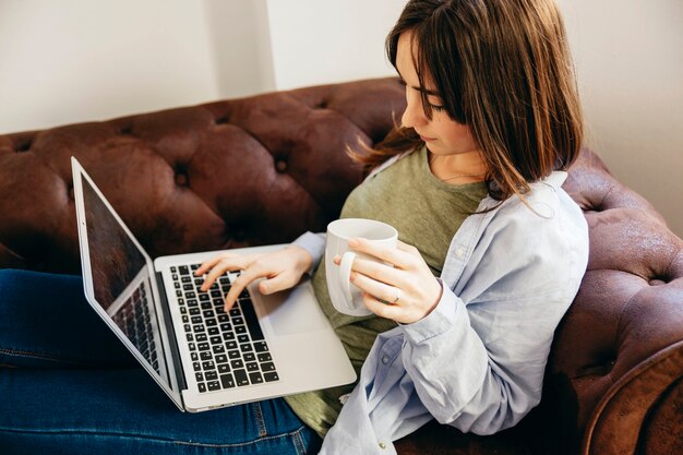 Woman chilling with drink and laptop