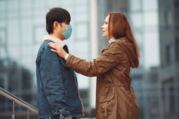 A woman and Chinese man are wearing protective masks