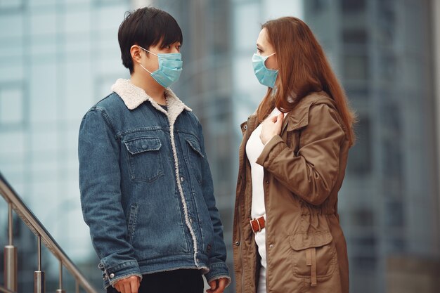 A woman and Chinese man are wearing protective masks