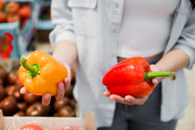 Woman choosing bell pepper in grocery store