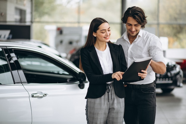 Woman choosing a car in a car showroom