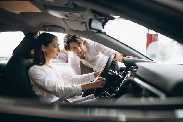 車のショールームで車を選ぶ女性