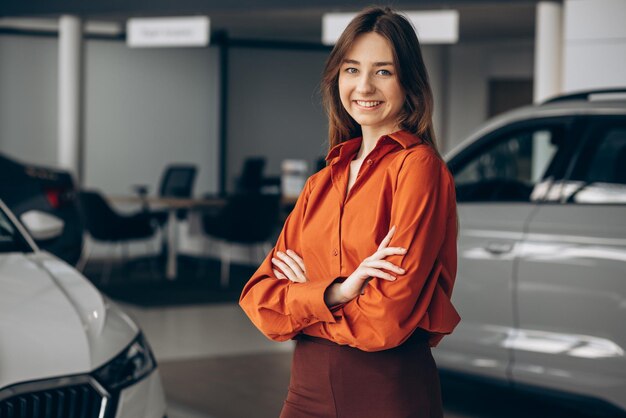 Woman choosing a car in a car showroom
