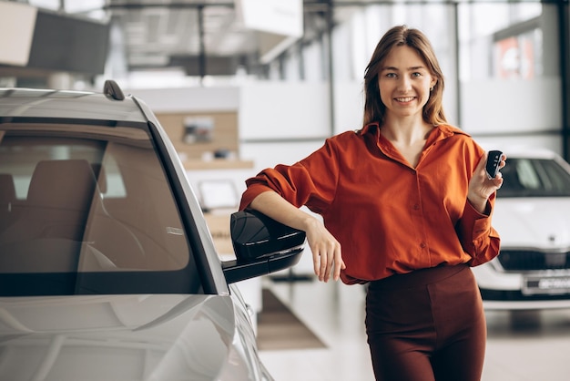 Woman choosing a car in a car showroom