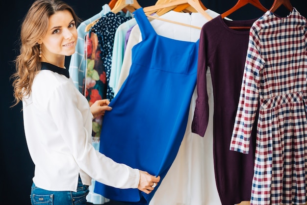 Woman choosing dress in shop