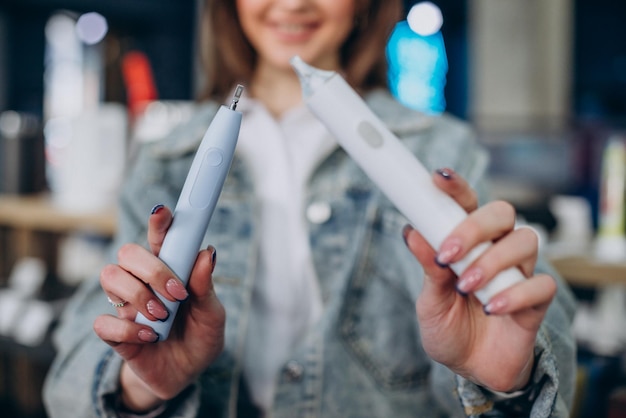 Woman choosing electric tooth brush at store