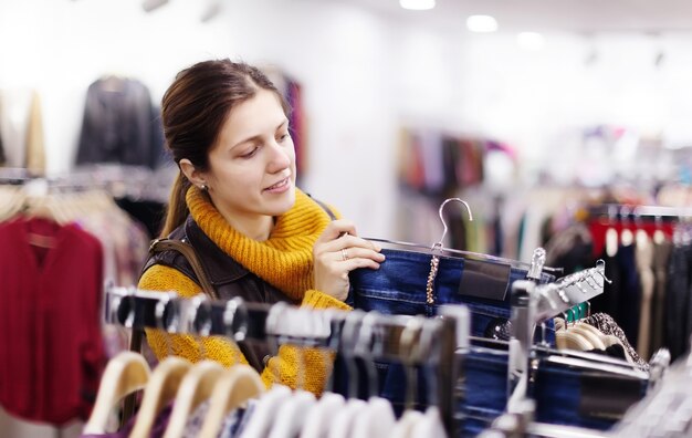 女性はジーンズを店で選ぶ