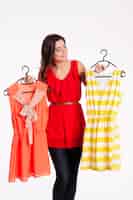 Foto gratuita donna che sceglie tra arancione e abito a righe