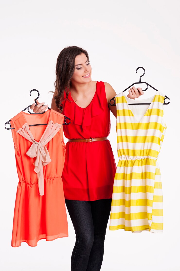 मुफ़्त फोटो woman choosing between orange and striped dress