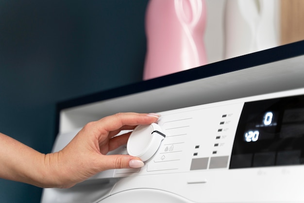 Woman choosing a program for the washing machine