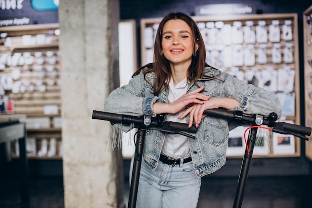 Женщина выбирает скутер в магазине техники