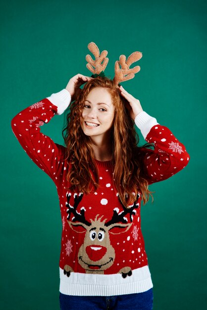 Woman in christmas clothes on green wall