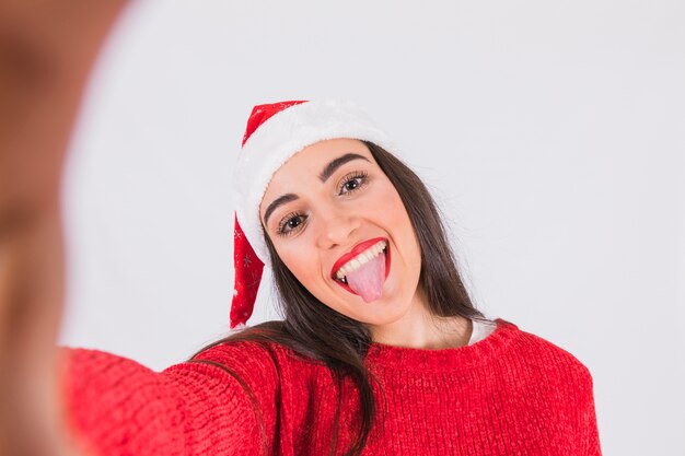 크리스마스 모자 혀를 보여주는 여자