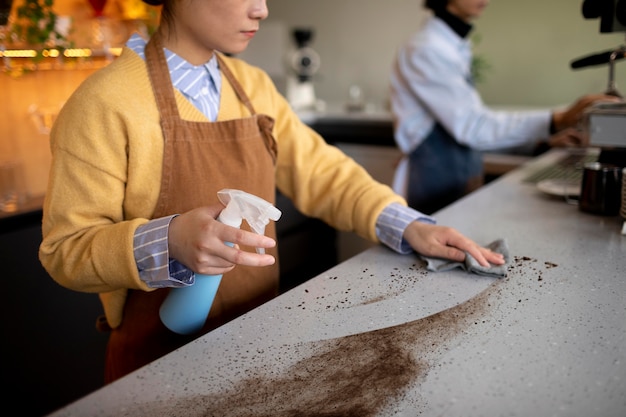 Donna che pulisce un piano di lavoro sporco