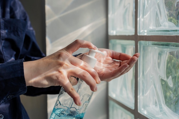 Woman cleaning hands with a hand sanitizer gel to prevent coronavirus contamination