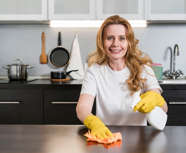 Foto gratuita donna che pulisce il tavolo da cucina