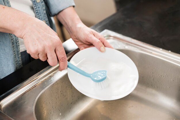 Woman cleaning a plate with brush