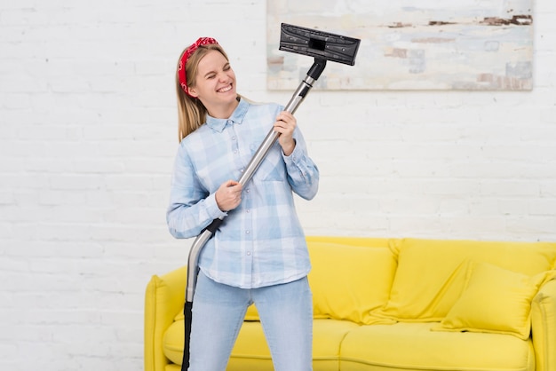 Free photo woman cleaning and playing with vacuum