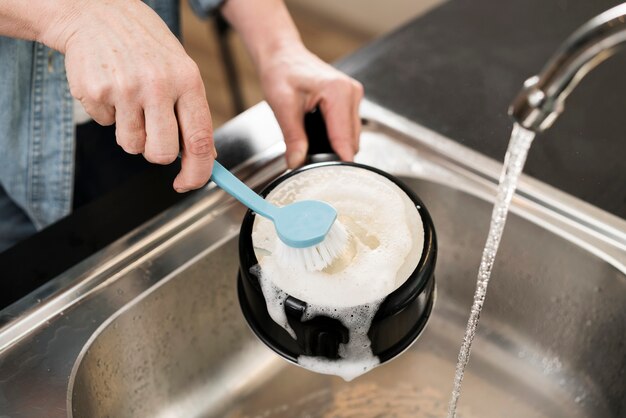 Woman cleaning pot with brush