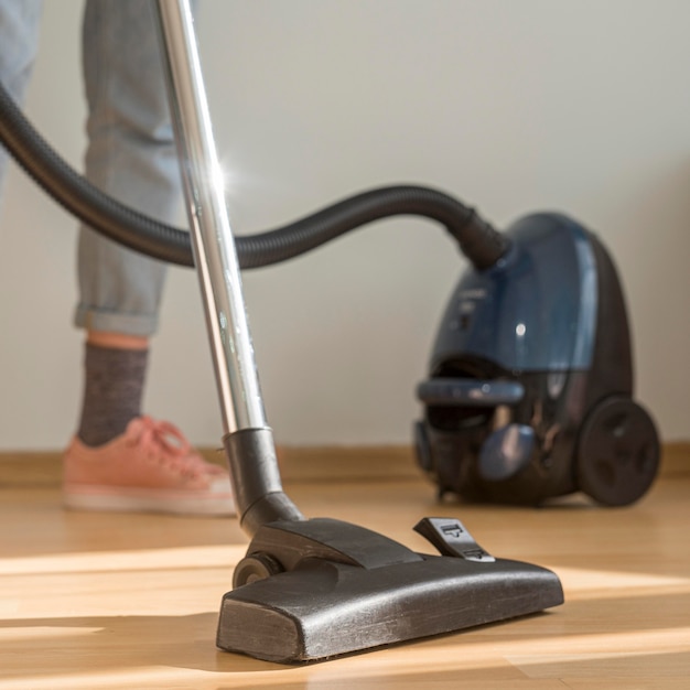 Woman cleaning room with vacuum cleaner