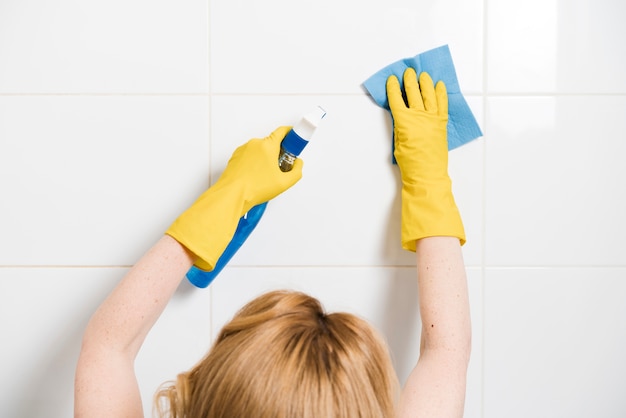 Free photo woman cleaning the shower wall