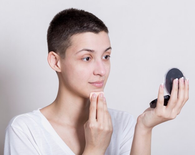 Woman cleaning while looking at herself in the mirror