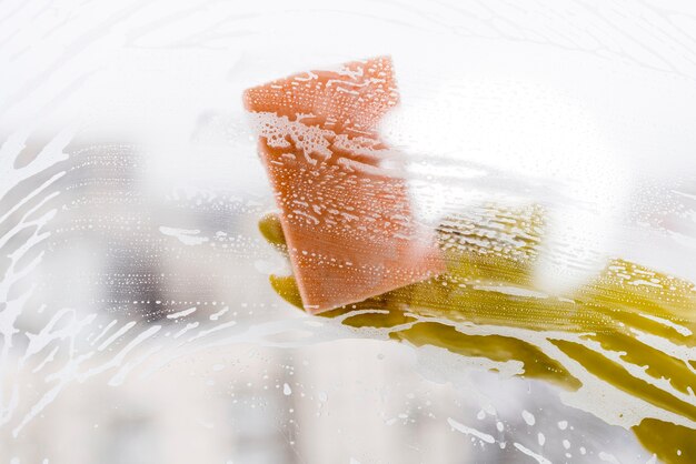 Woman cleaning window with sponge