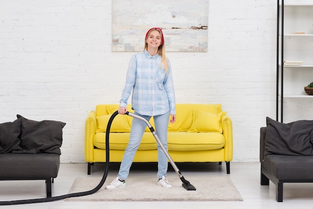 Free photo woman cleaning with vacuum cleaner