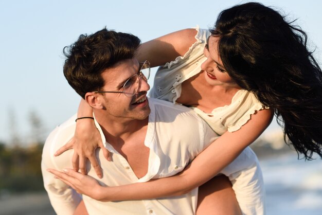 Woman climbed on a man's back on the beach