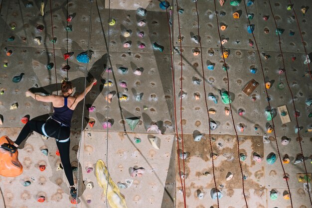 Woman climbing high wall