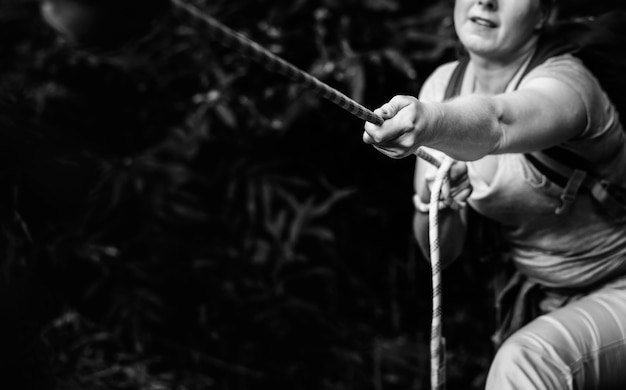 Free photo woman climbing up a rope