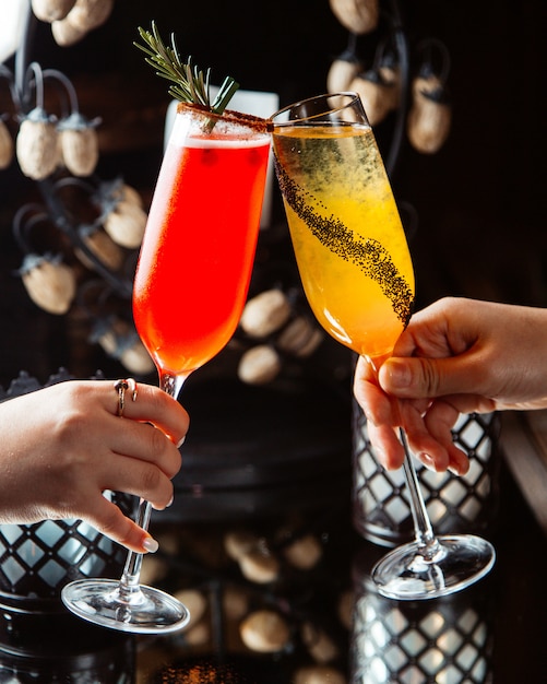 Foto gratuita bicchieri di champagne tintinnio donna con cocktail di agrumi