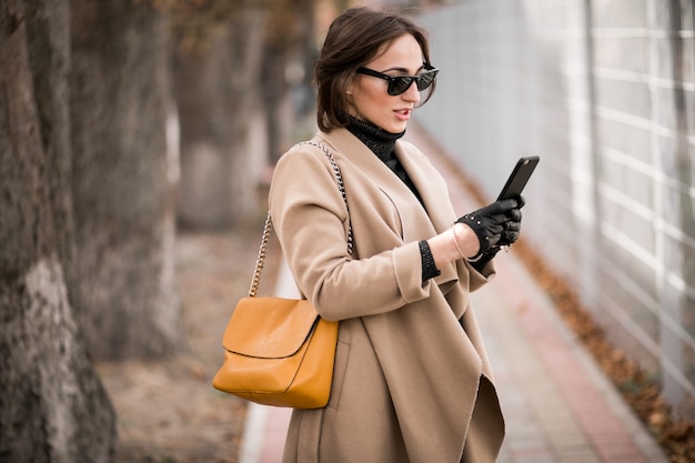 Free photo woman in coat with phone