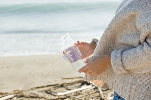 Woman collection bottle from seaside