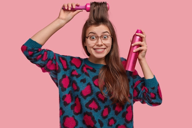 Free photo woman in colorful sweater doing her hairstyle