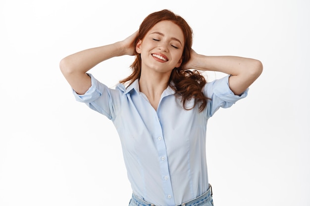 woman, comb red hair and smiling with eyes closed, having break, resting and enjoying leisure, standing on white