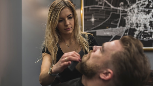 Woman combing beard of man