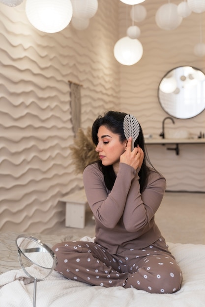 Woman combing hair during her beauty routine