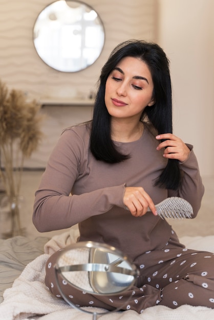 Woman combing hair during her beauty routine