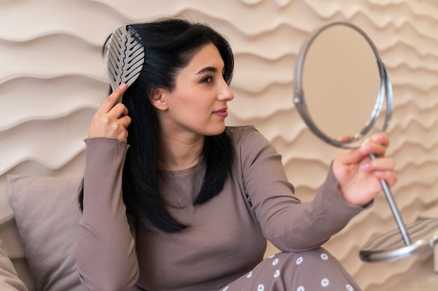 Woman combing hair during her beauty routine