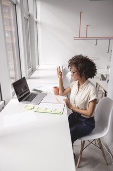 ノートパソコンでオンライン手話で通信する女性